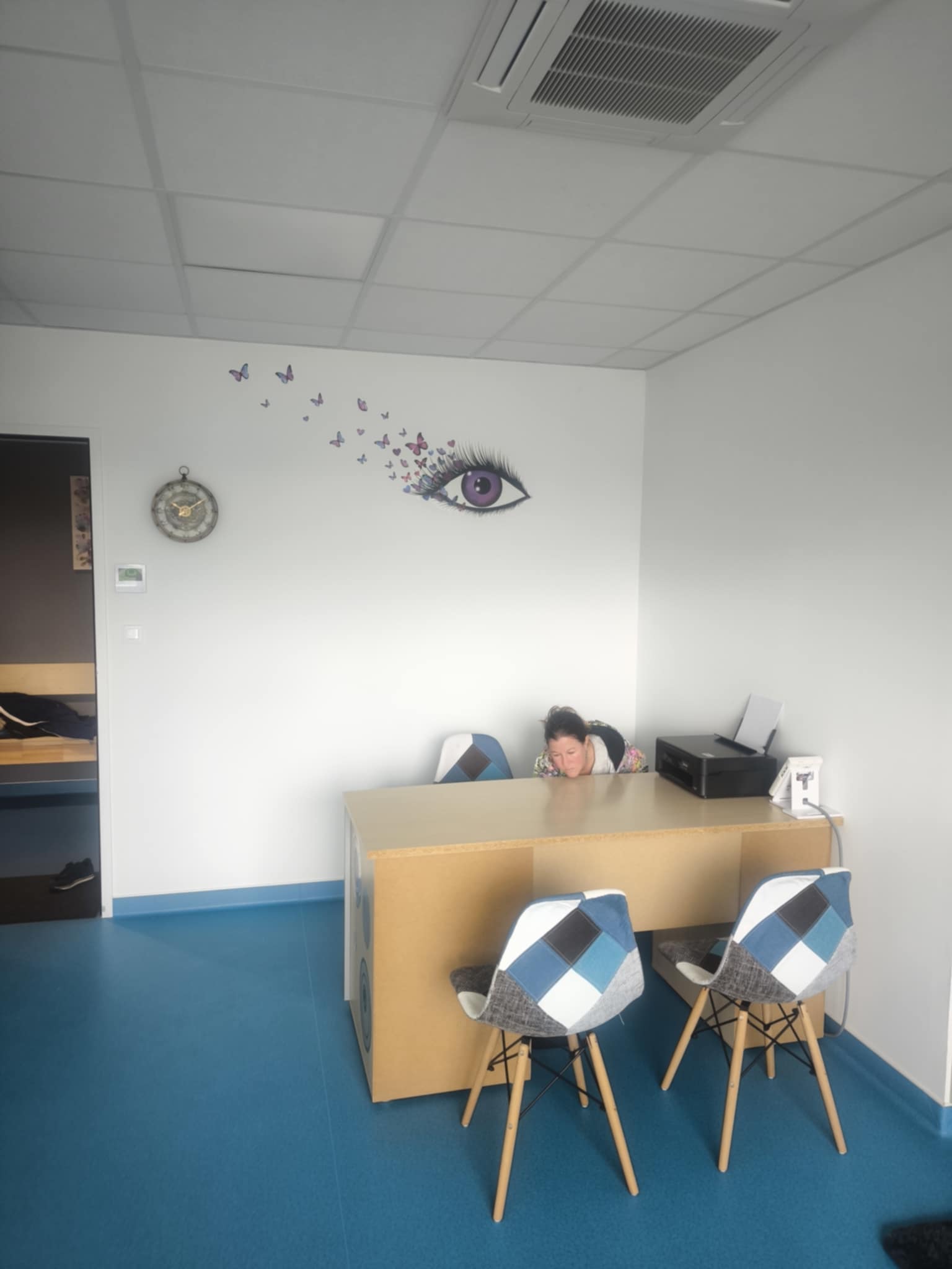 Une pièce avec un bureau et des chaises, offrant un espace de travail fonctionnel et accueillant.